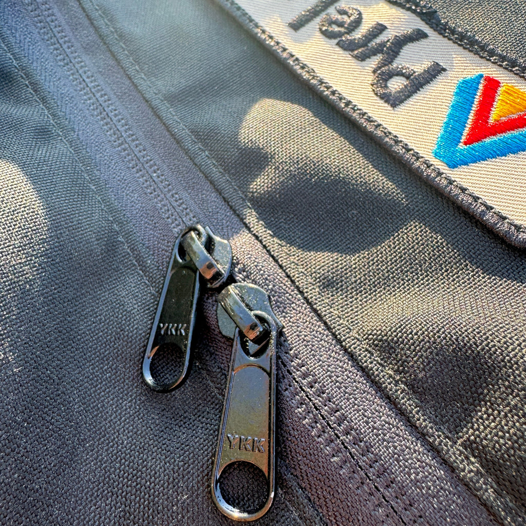 Close-up of a gray bag with a zipper and a visible brand logo.