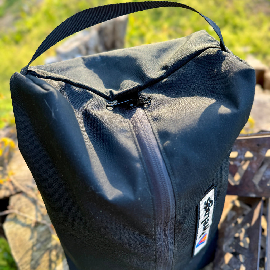 Black bag with a visible brand logo on a natural background