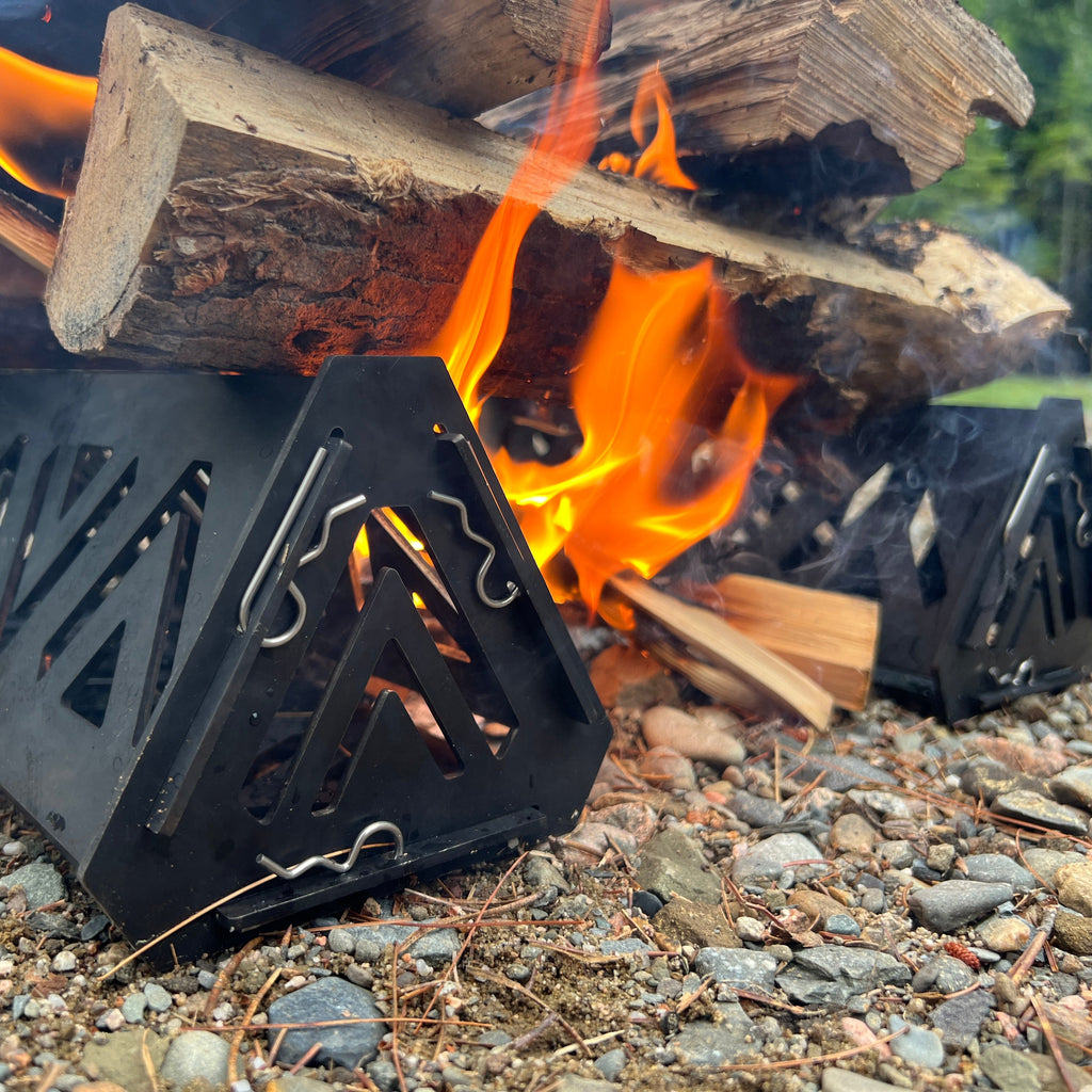 Fire pit with burning wood on a rocky ground
